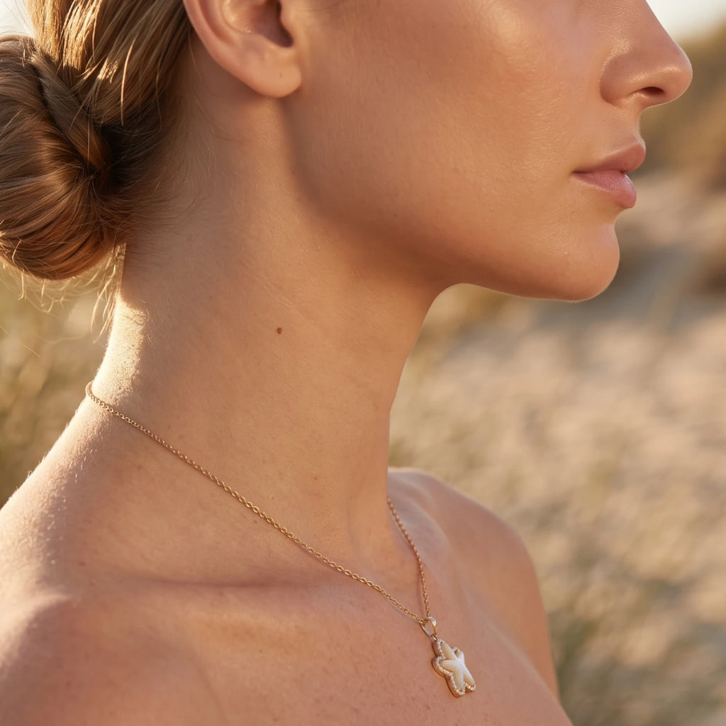 Gold necklace with a starfish and pearl detailing by Kloreys
